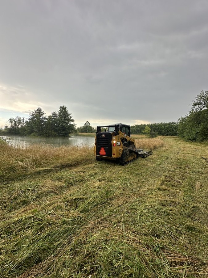 skid steer next to a pond